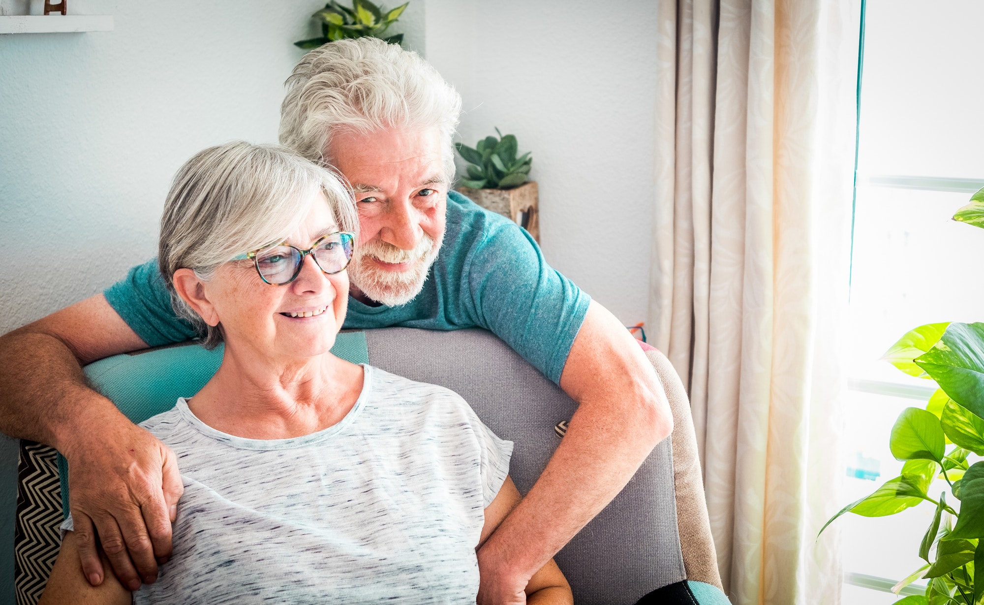 Happy senior couple relax at home on the armchair respecting the quarantine for Covid-19