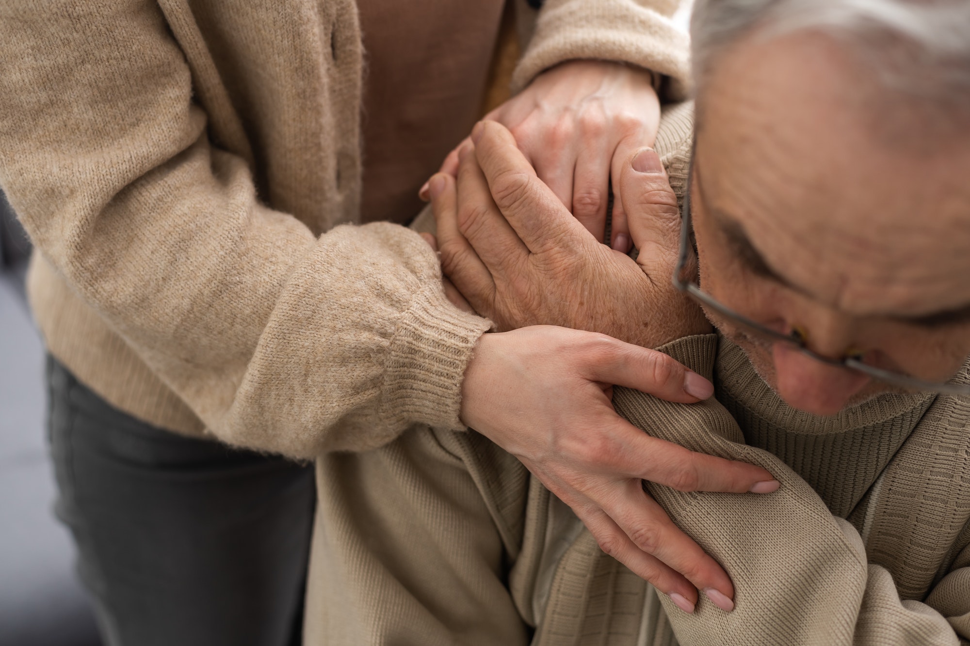 Head shot old male pensioner involved in rehabilitation procedure with caring young physiotherapist